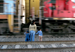  Una madre y su hija frente a un tren que pasa rápidamente