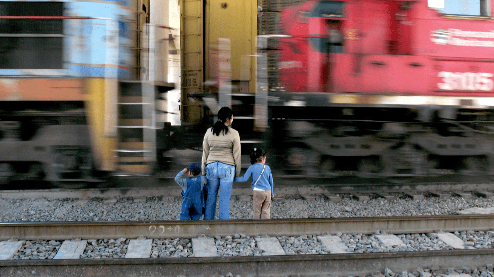  Una madre y su hija frente a un tren que pasa rápidamente